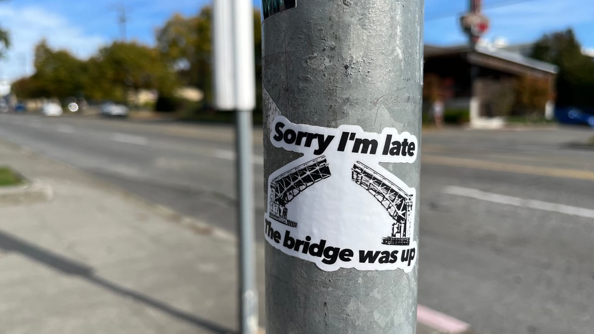 sticker with a drawing of a bridge separated in the middle. the text reads "sorry I'm late the bridge was up"
