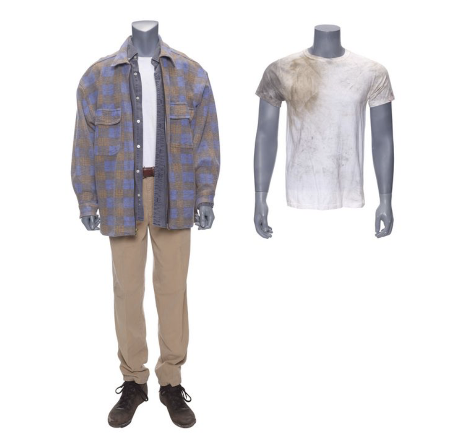 one grey headless mannequin wearing white t-shirt, blue overshirt, and blue, yellow plaid overshirt, with khaki pants and brown boots. a second mannequin of just a torso and arms wears a white t-shirt with dirt on the shoulder