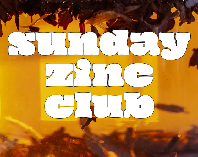 closeup of tea leaves steeping in orange water. the white text overlaid reads Sunday Zine Club